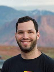 Headshot of Benjamin (Benji) Smith, smiling with a dark shirt