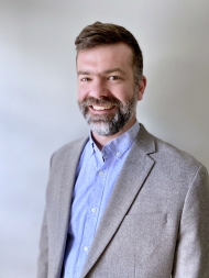 Headshot of Erick Guerra, wearing a blue suit 